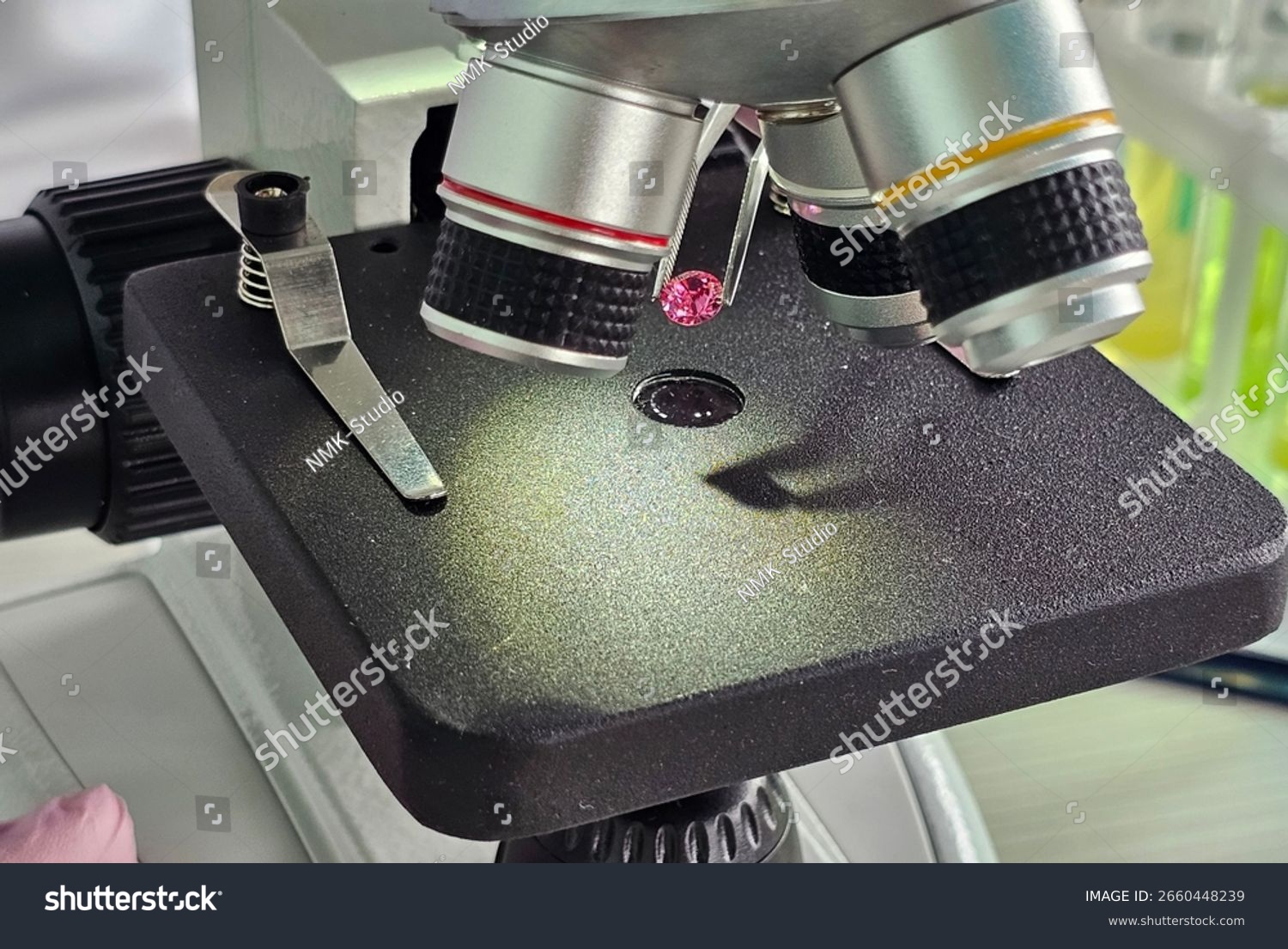 Gemologist testing a gemstone under a microscope